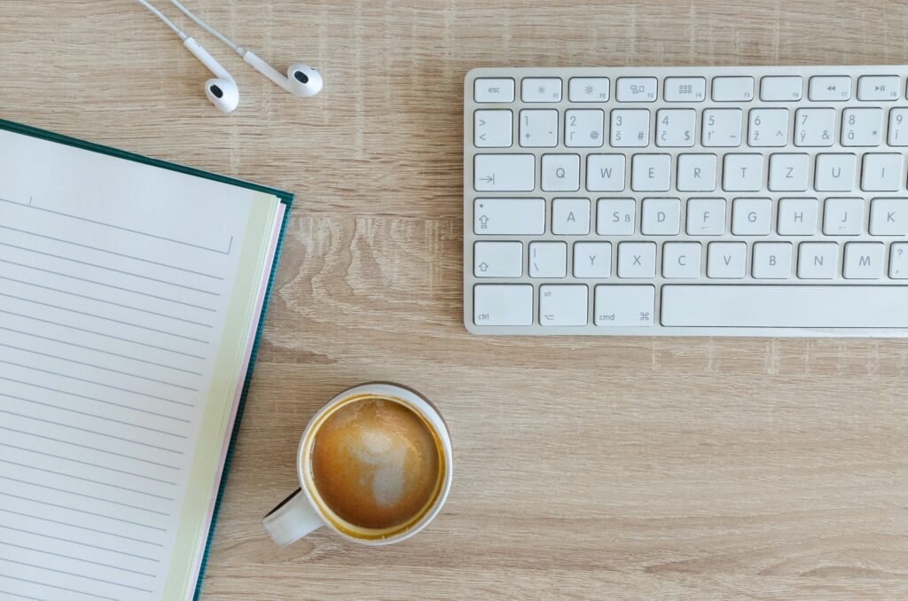 L'ordinateur portable, les écouteurs, le café et le clavier sont représentés sur cette image.